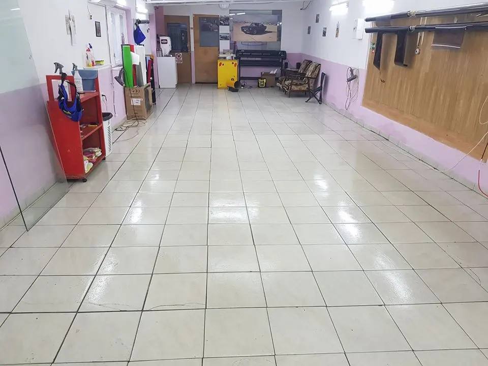 Interiorul unui atelier de montaj folie auto: curat, luminos, cu gresie pe jos