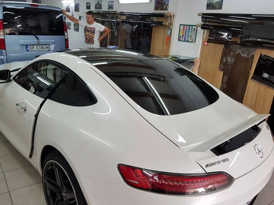 Mercedes-AMG GT alb, cu folie fumurie pe geamuri, în atelier